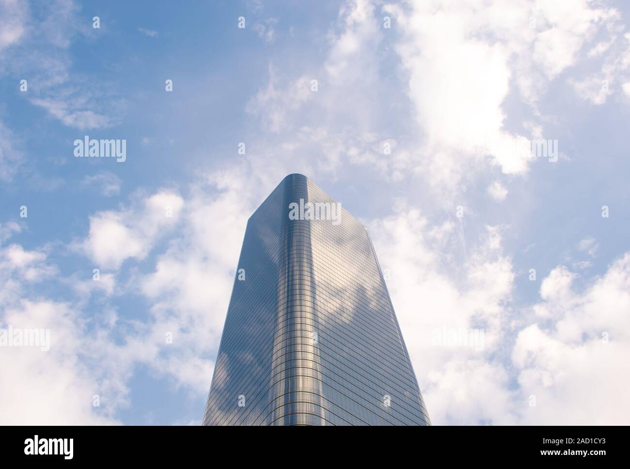 Tall glass building with cloudy sky background - center bright - space for caption Stock Photo