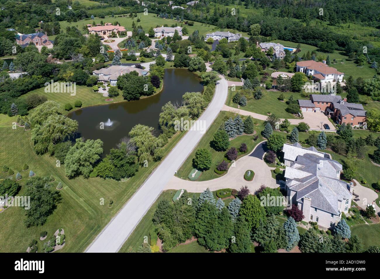 Aerial view of a luxury neighborhood with large homes and a pond in a Chicago suburban neighborhood during summer. Stock Photo