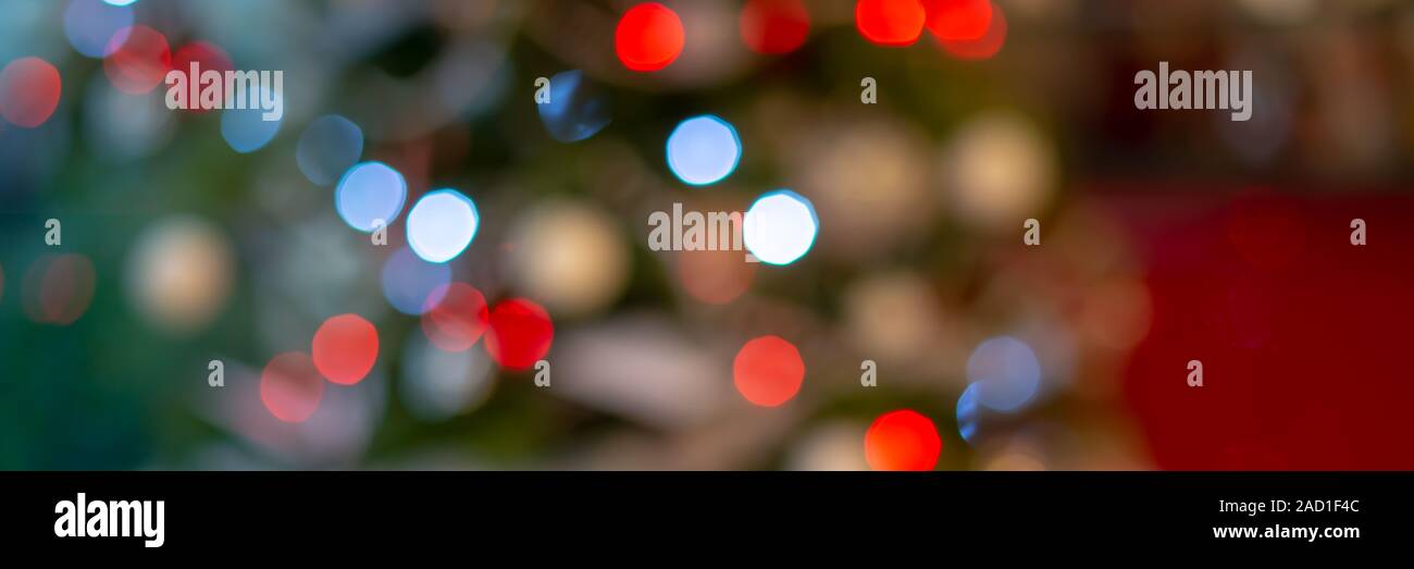 Panoramic banner of blurred green and red bokeh holiday lights at night, christmas tree background Stock Photo