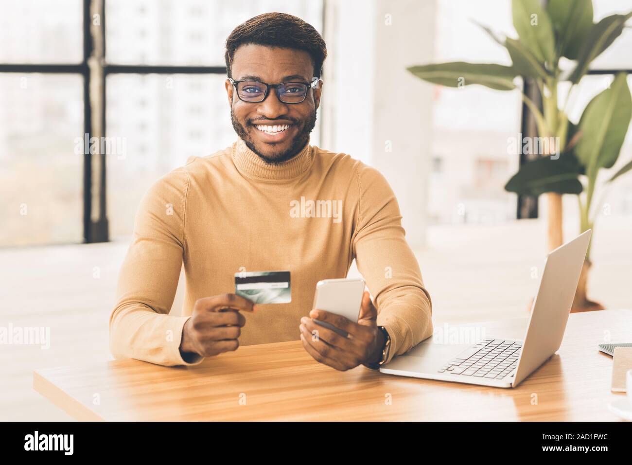 African american man holding credit card and smartphone Stock Photo - Alamy