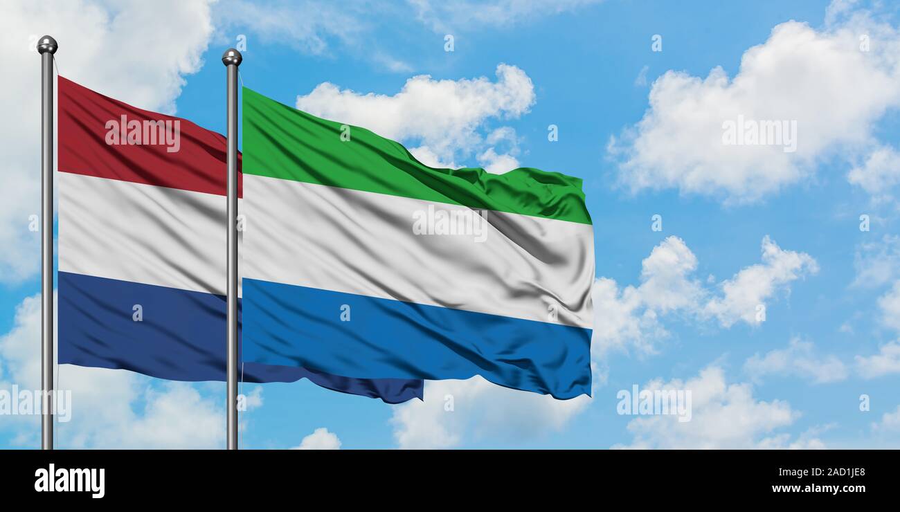 Netherlands and Sierra Leone flag waving in the wind against white cloudy blue sky together. Diplomacy concept, international relations. Stock Photo