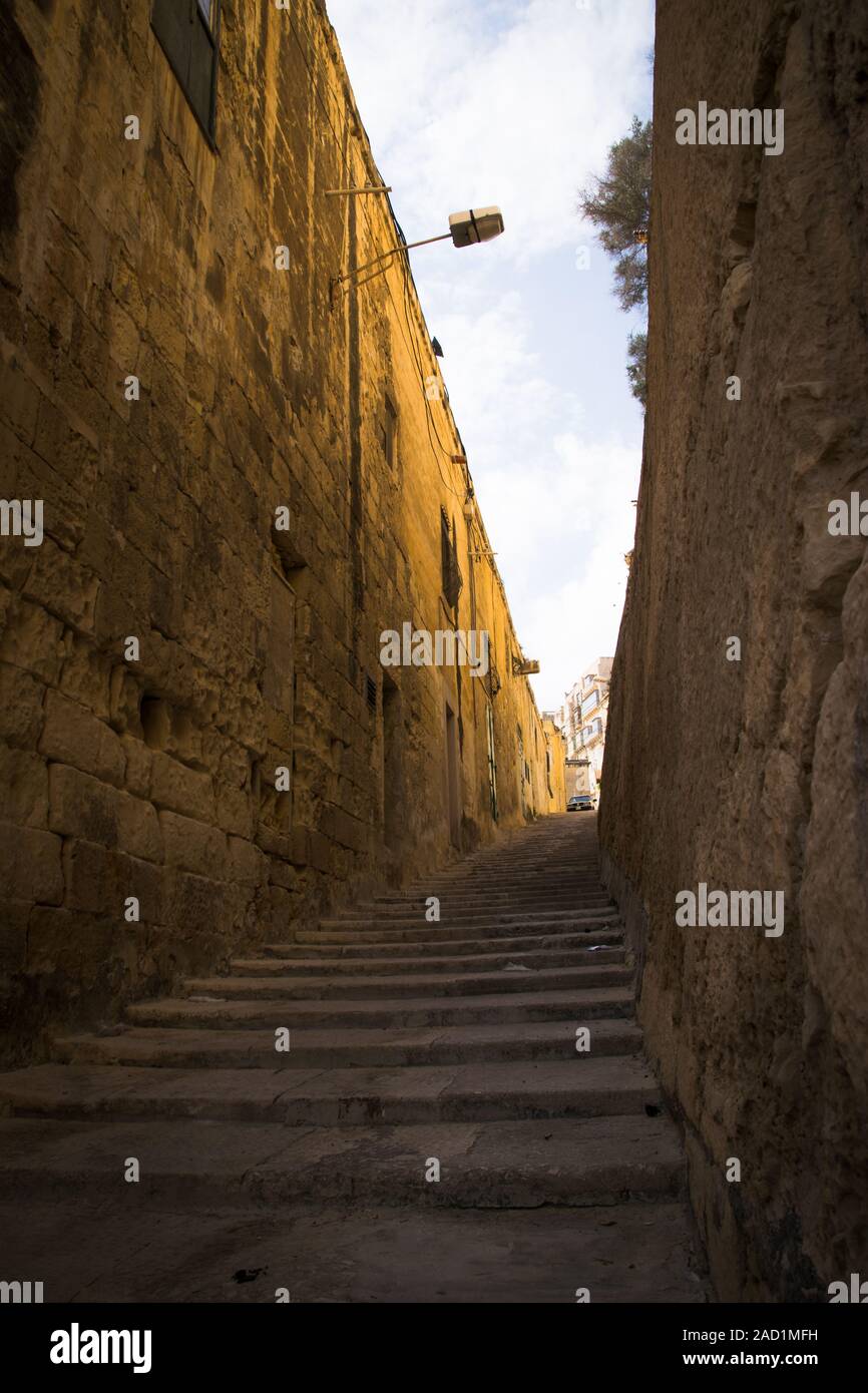 typical narrow street with stairs in the city Valetta on the island of Malta Stock Photo