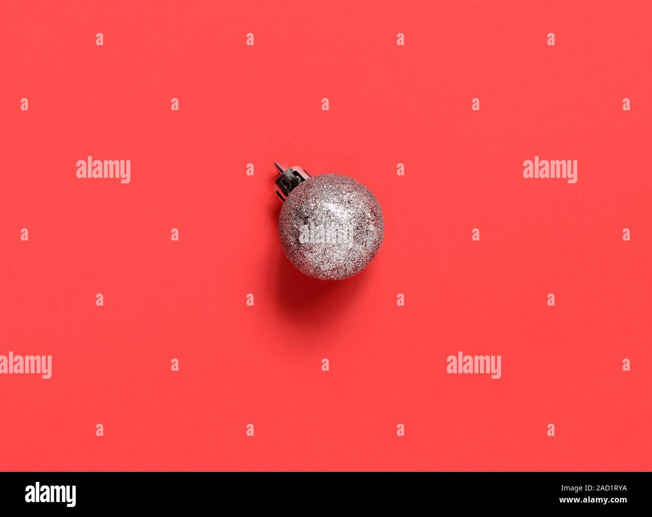 Silver Christmas bauble on a coral red backgroundtop view Stock Photo