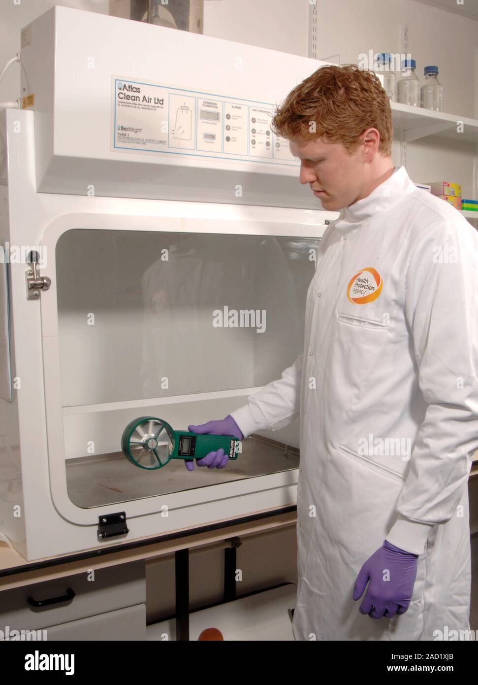 Fume cupboard safety testing. Scientist working for the UK's Health Protection Agency using an