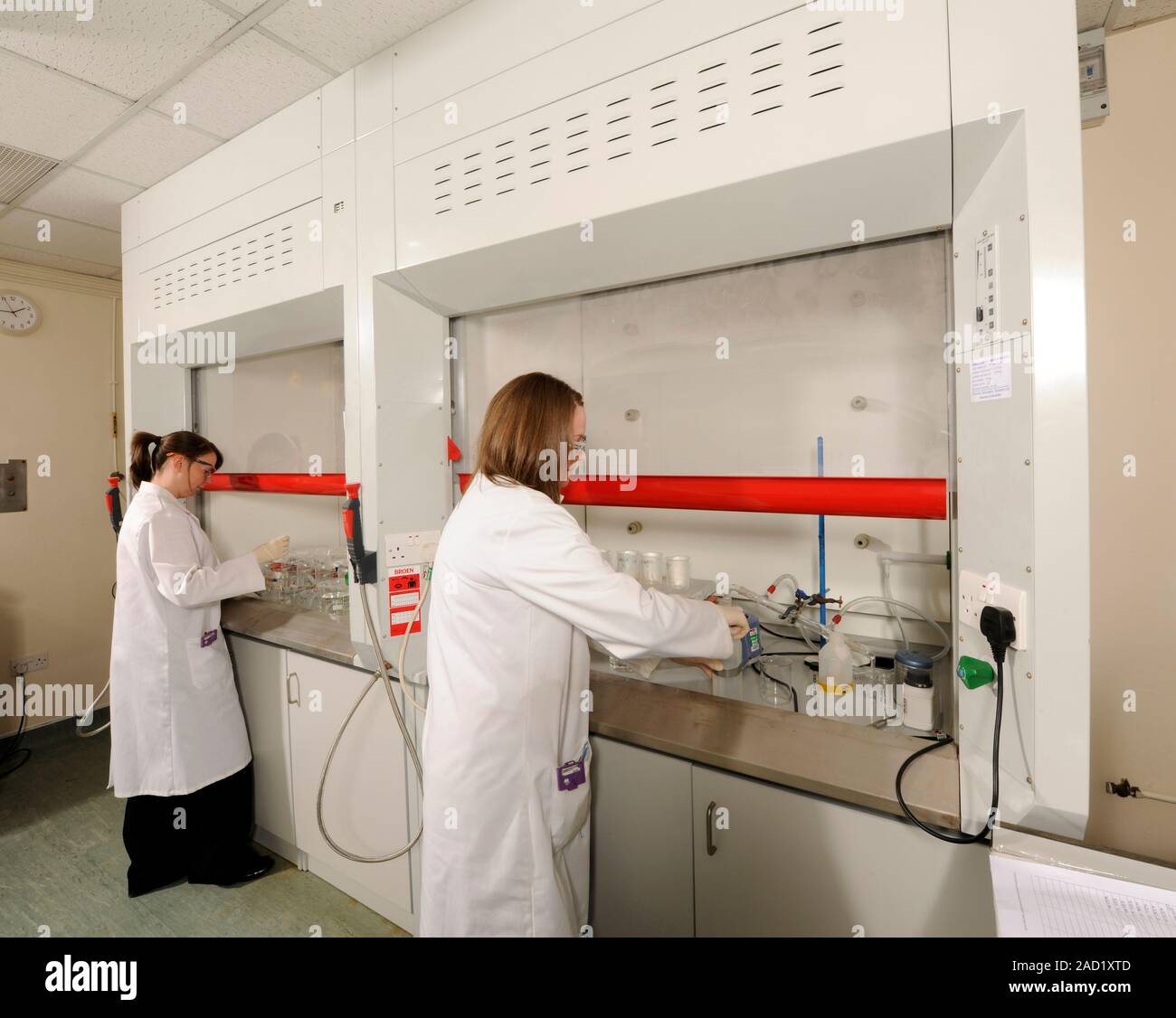 Radioisotope analysis. Scientists handling radioisotopes in fume