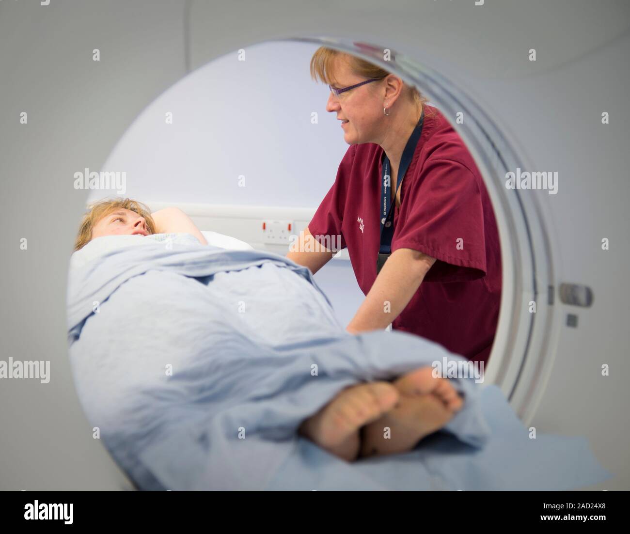 Radiographer preparing a CT scan. Radiographer talking with a patient ...