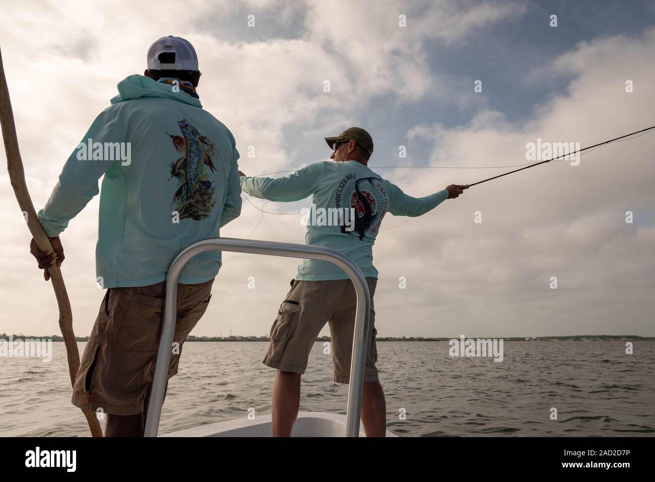 Ambergris Caye, Belize - November, 16, 2019.   Local fishing guide instructs a fly fisherman on casting technique used in saltwater fishing as he stan Stock Photo