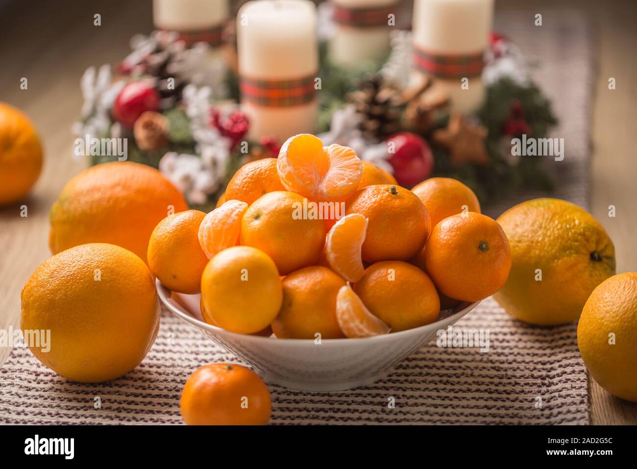 Tangerines and oranges on christmas table with advent wreath Stock