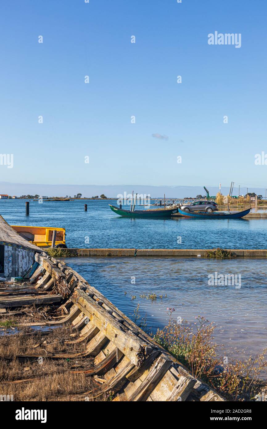 Aveiro, Portugal. High tide floods over the banks of the lagoon.  In the foreground are rotting hulls of Moliceiros traditional boats Stock Photo