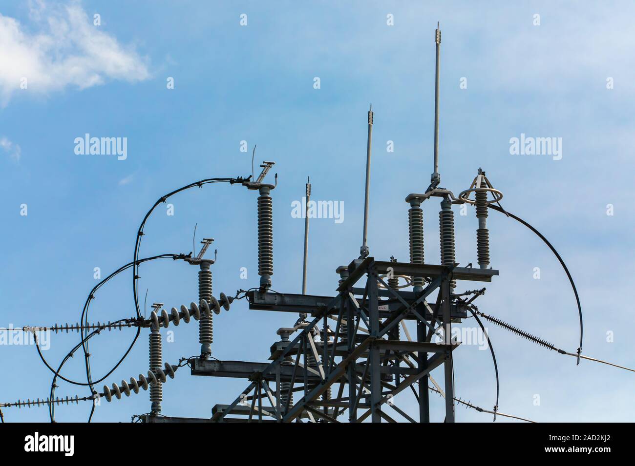 high voltage electrical substation tower top, close up, open electrical Isolator for Electrical Isolation Switch, in low angle view against the sky Stock Photo