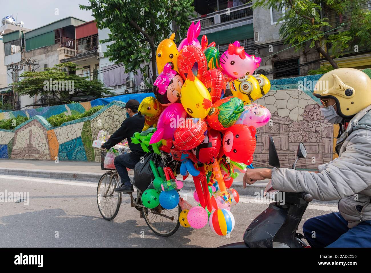 Vietnamese balloon vendor riding bicycle loaded up with colourful balloons  Stock Photo - Alamy