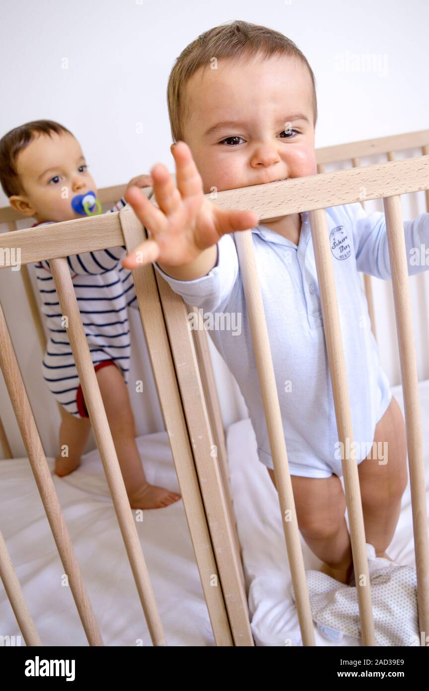 Twin baby boys in their cots. 13monthold twin baby brothers playing