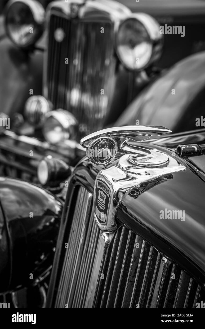 Black and white close up of the hood, bonnet ornament on a classic, vintage Morris Eight 8 motor car parked at a 1940's WWII event, Great Britain. Stock Photo