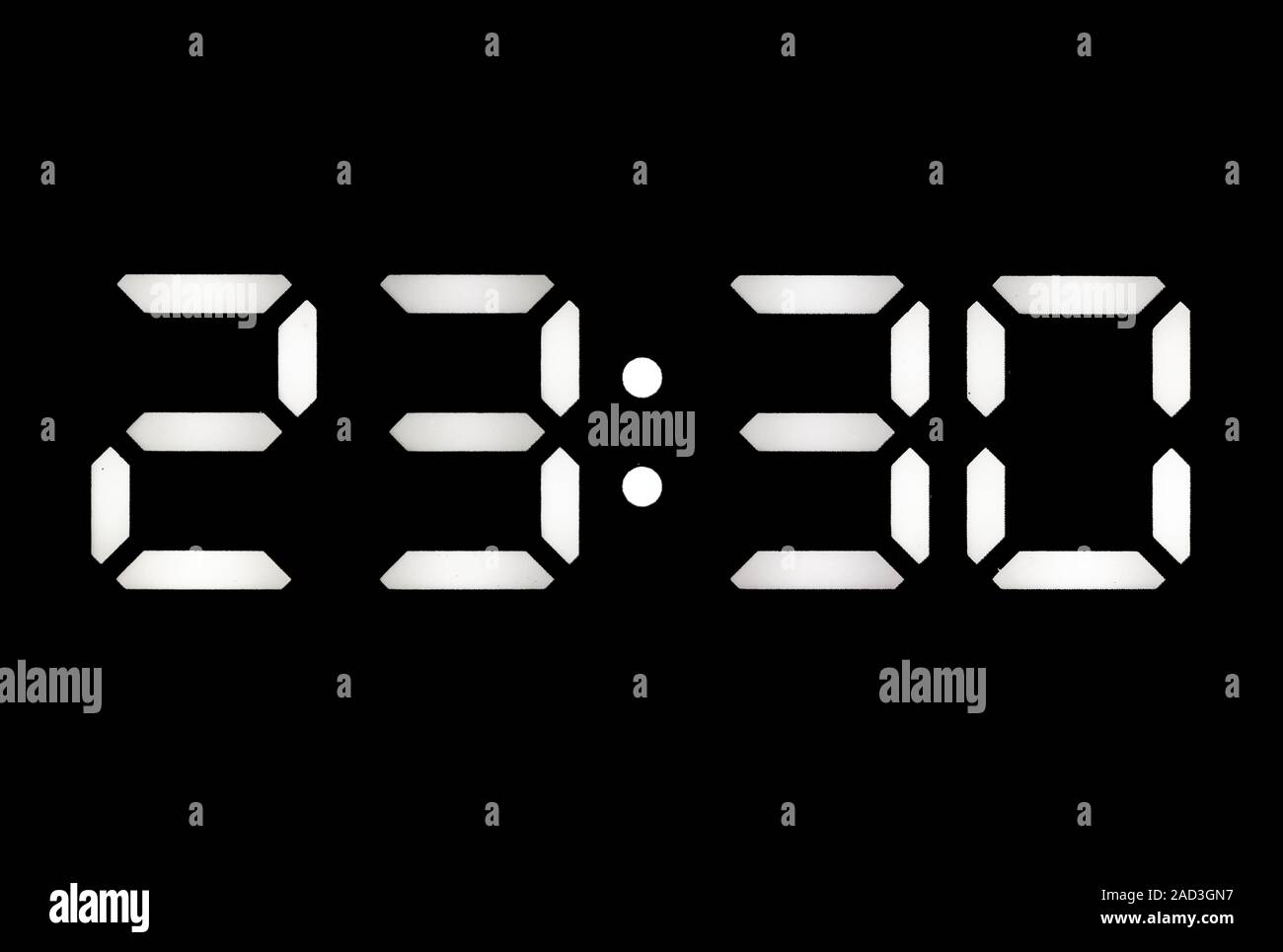 Real white led digital clock on a black background showing time 23:30 ...