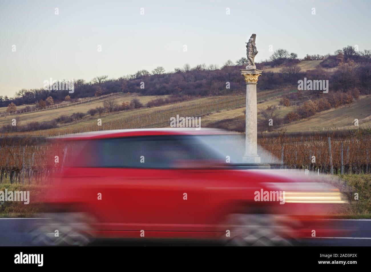 Image of Saint Sebastian on the country road with red car Stock Photo