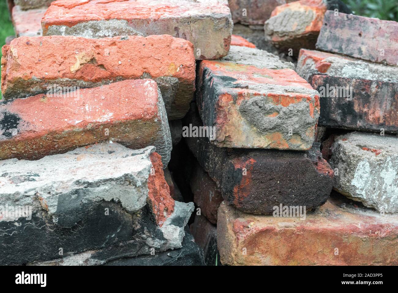 Pile of old broken dirty burnt bricks with remnants of cement Stock