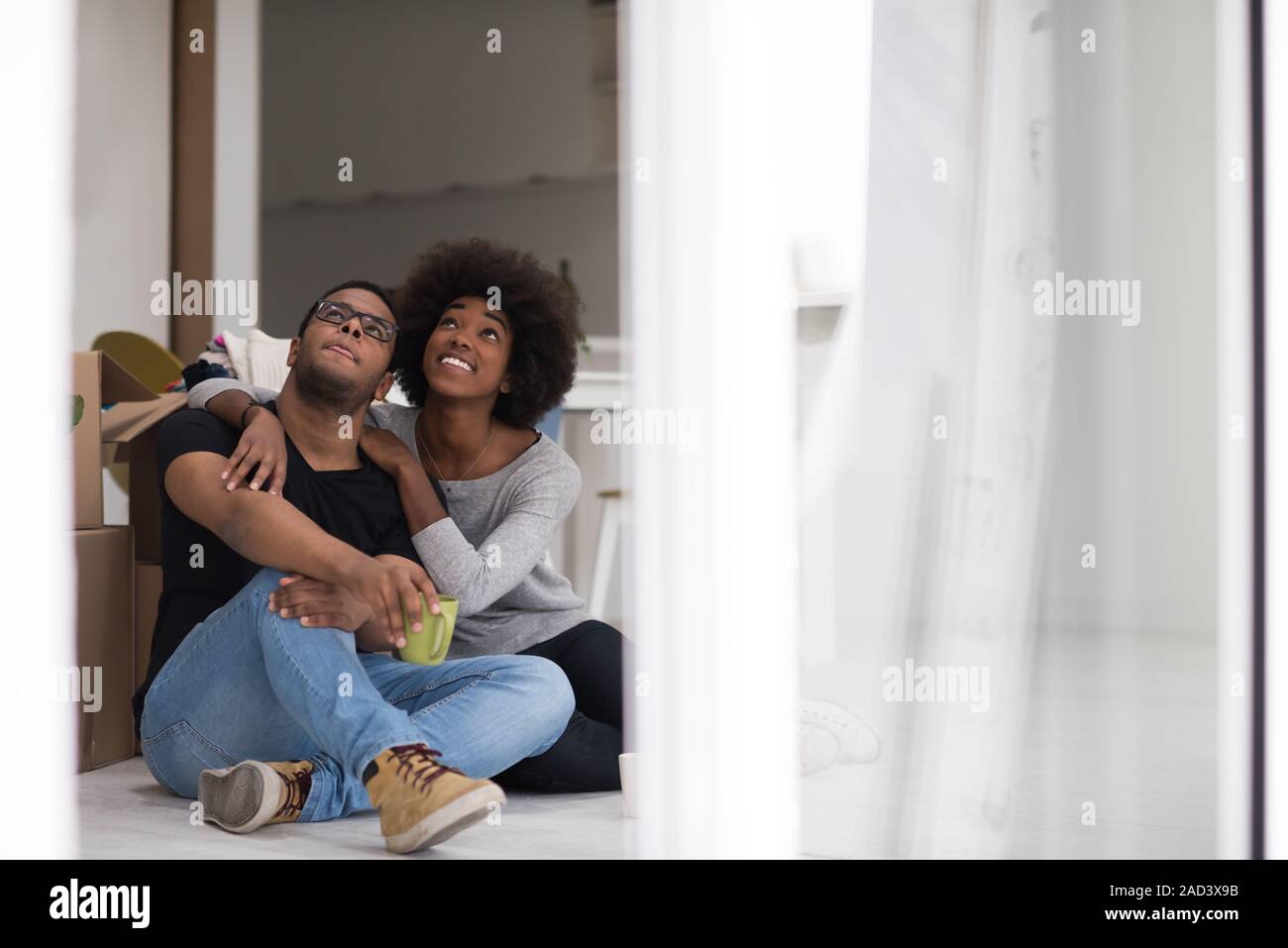 African American couple relaxing in new house Stock Photo - Alamy