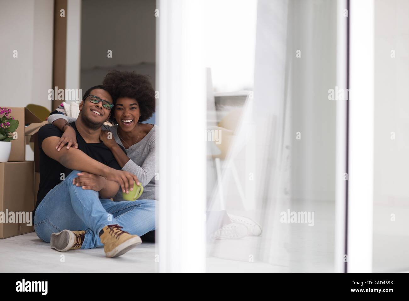 African American couple relaxing in new house Stock Photo - Alamy