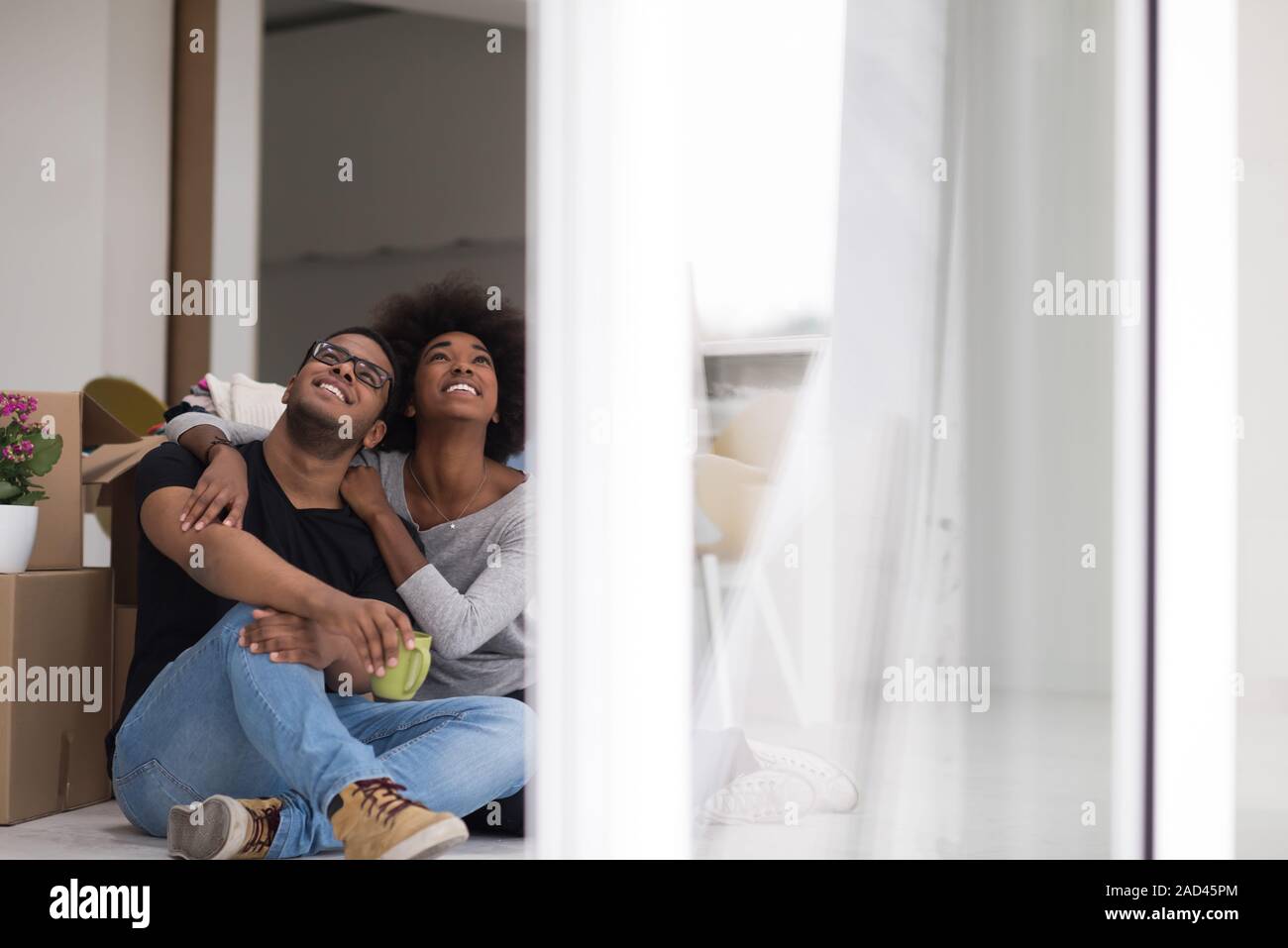 African American couple relaxing in new house Stock Photo - Alamy