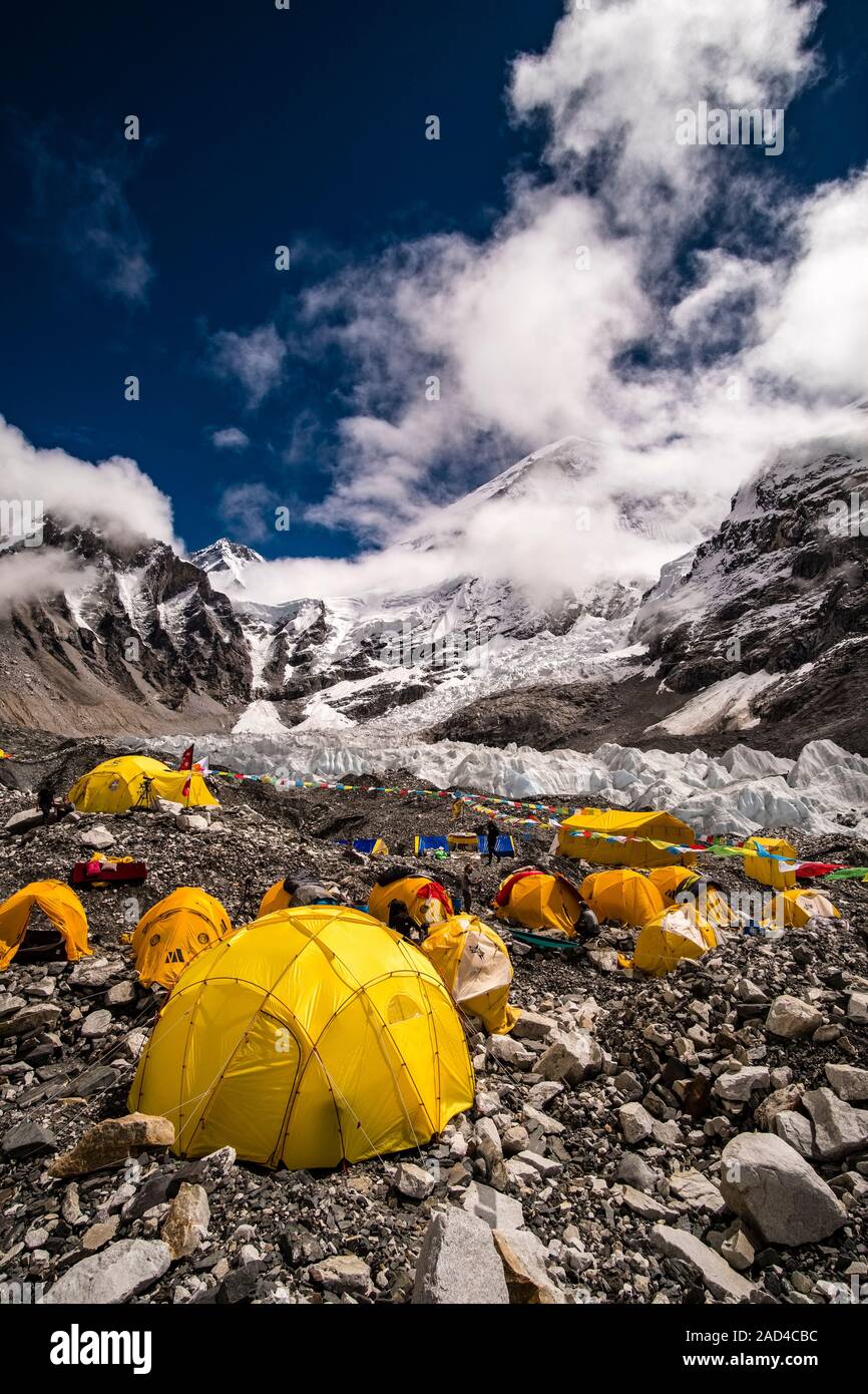 Tents set up at Everest Base Camp on Khumbu glacier, Mt. Everest behind covered by monsoon clouds Stock Photo