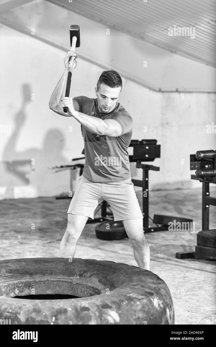 man workout with hammer and tractor tire Stock Photo Alamy