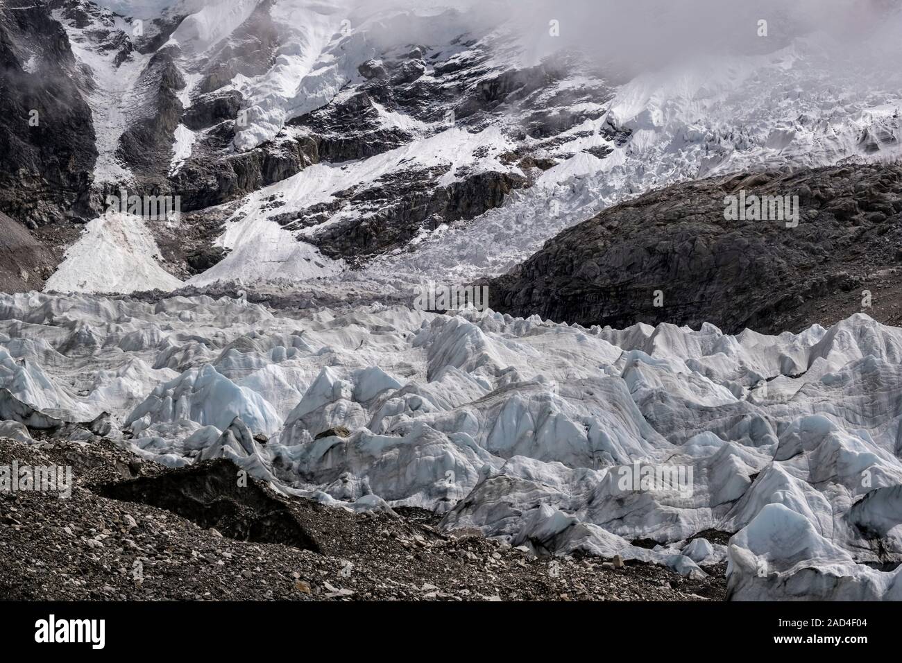 Ice formations on Khumbu glacier, Khumbu Icefall behind covered by monsoon clouds Stock Photo