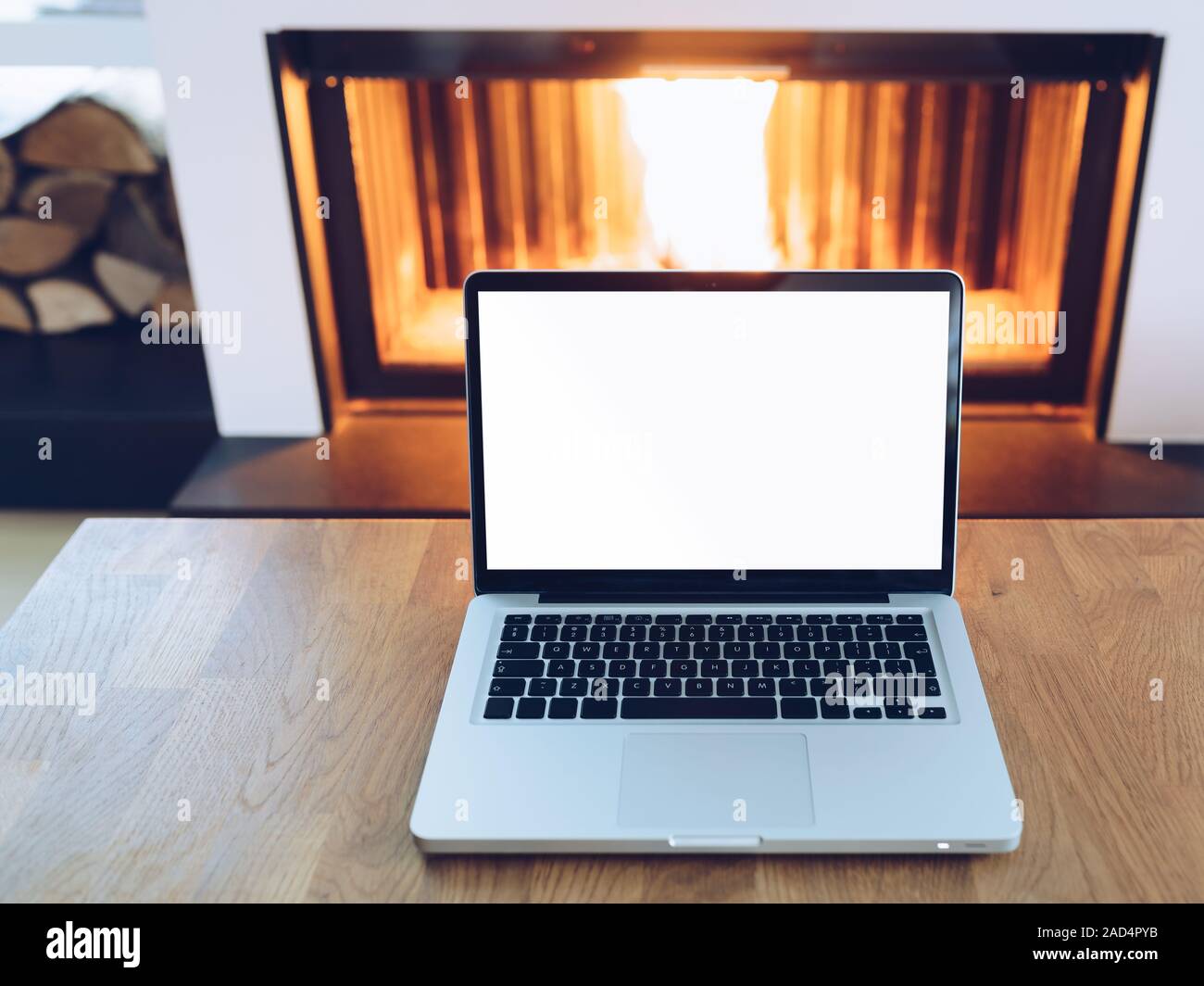 Laptop With Blank Screen On Wooden Table In Front Of Burning