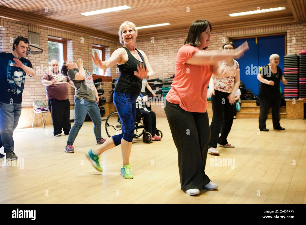 Exercise class for disabled people. Dance instructor and a group of