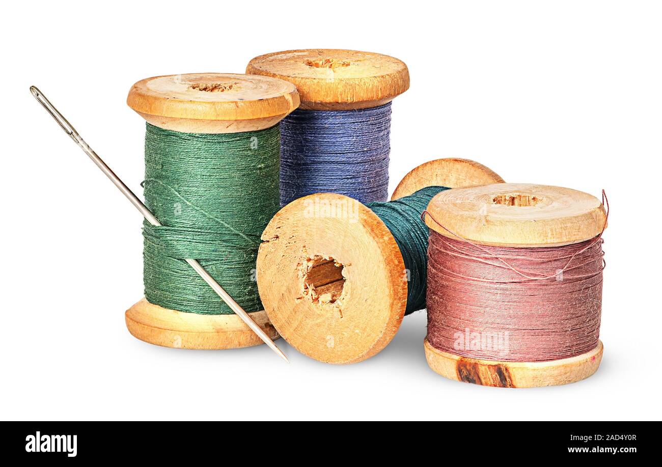 Needle and multicolored thread on wooden spool Stock Photo