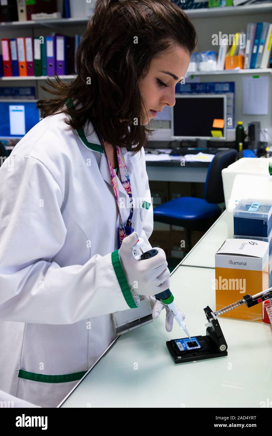 Genetic microarray preparation. Analyst pipetting a prepared DNA (deoxyribonucleic acid) sample onto a gene chip or microarray. This device is used wi Stock Photo