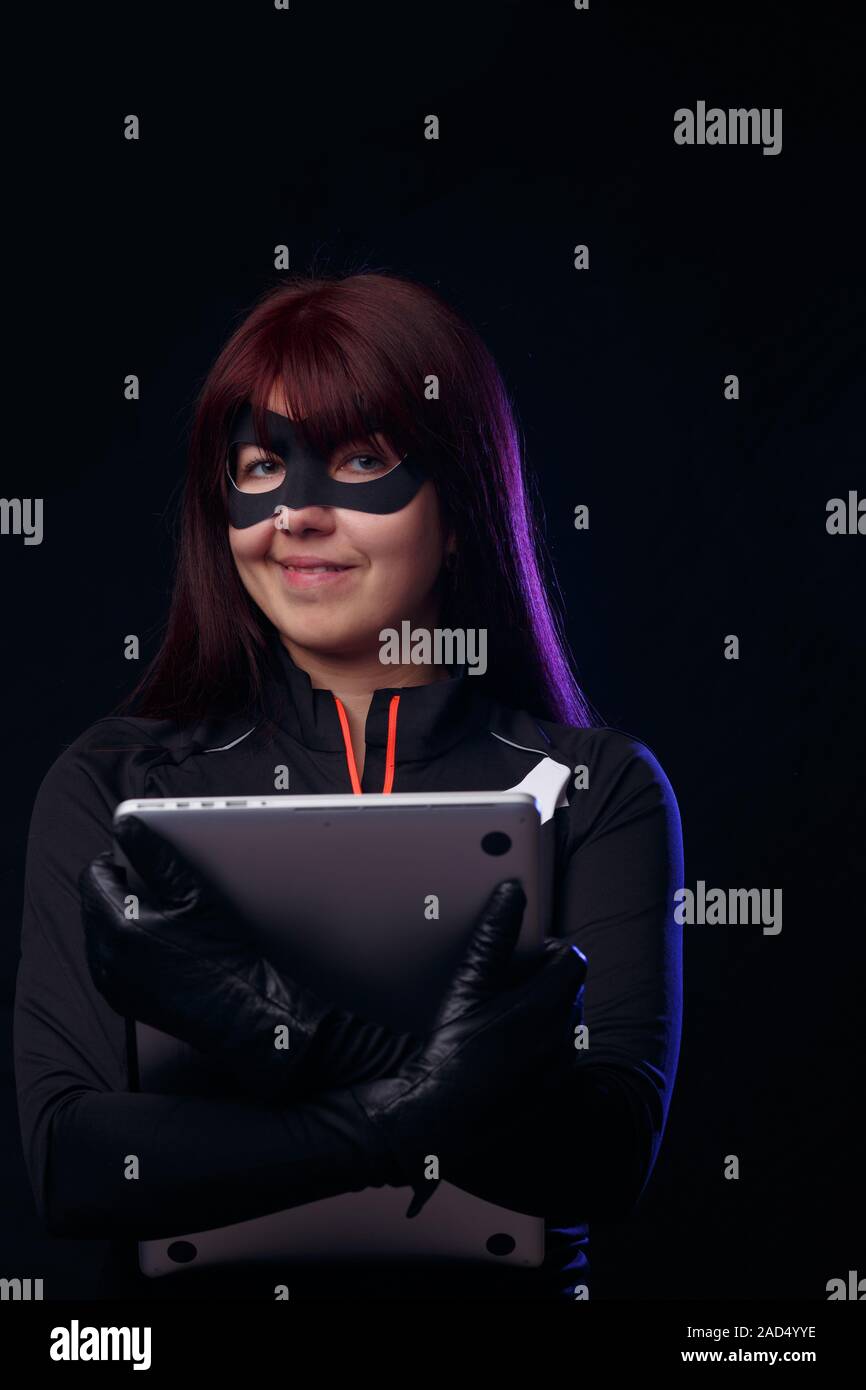 Brunette thief holds stolen laptop Stock Photo - Alamy