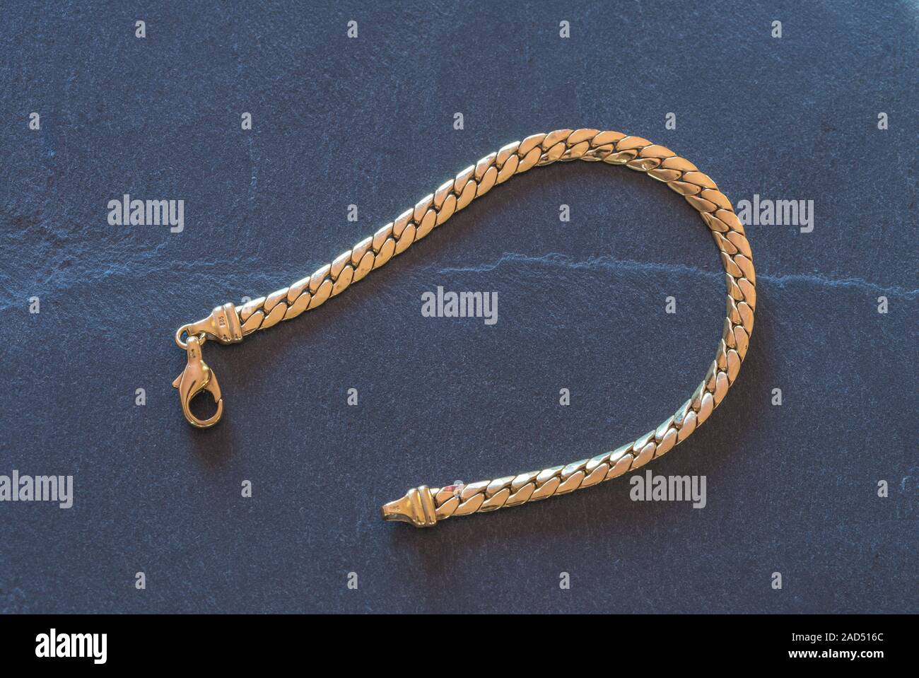 Gold bracelet / gold jewellery against dark background Stock Photo