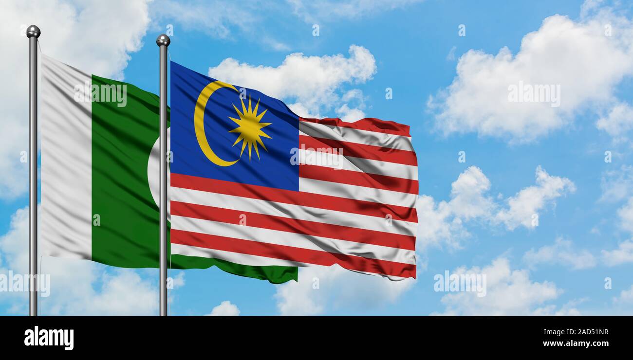 Pakistan and Malaysia flag waving in the wind against white cloudy blue ...