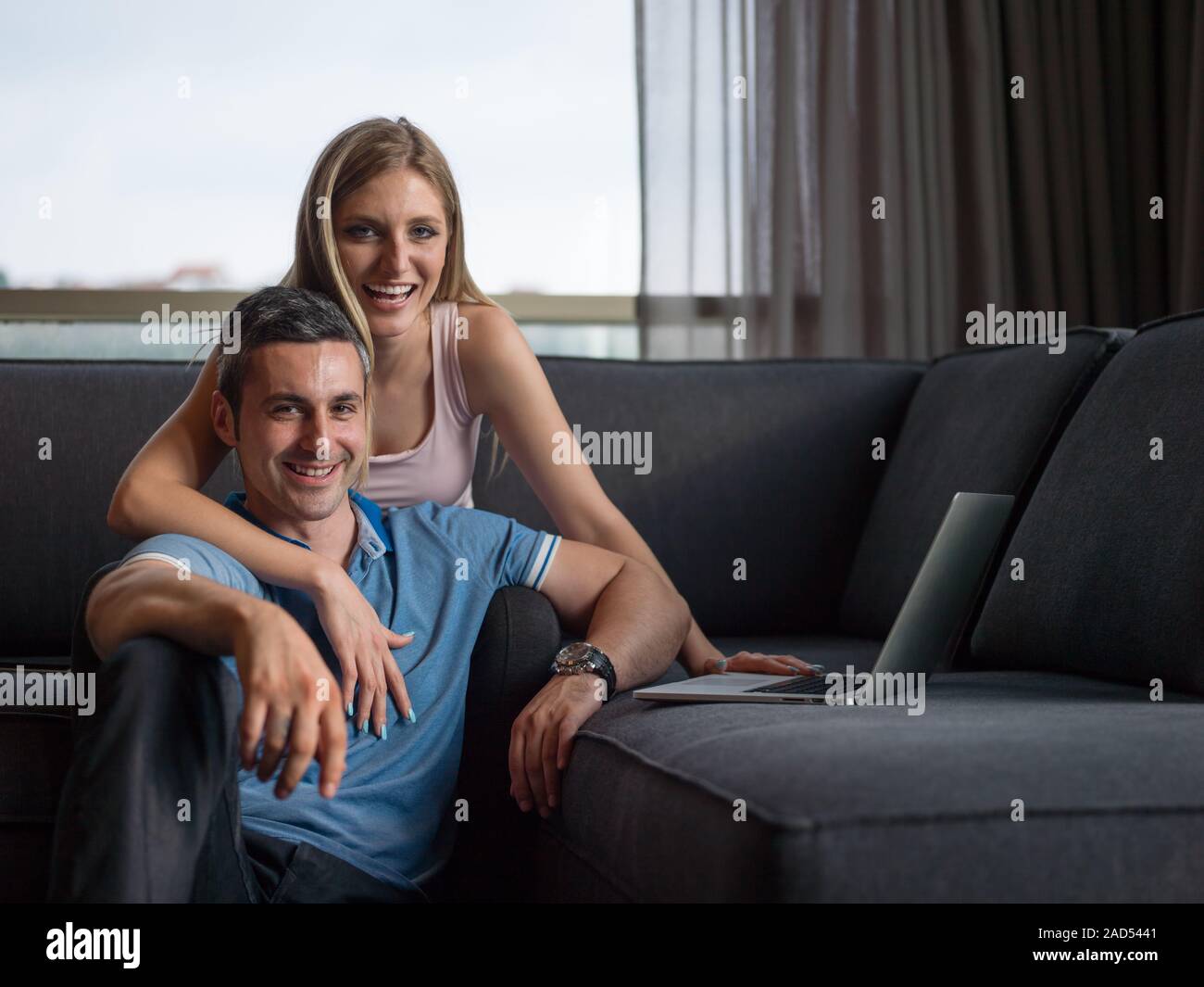 Attractive Couple Using A Laptop on couch Stock Photo - Alamy
