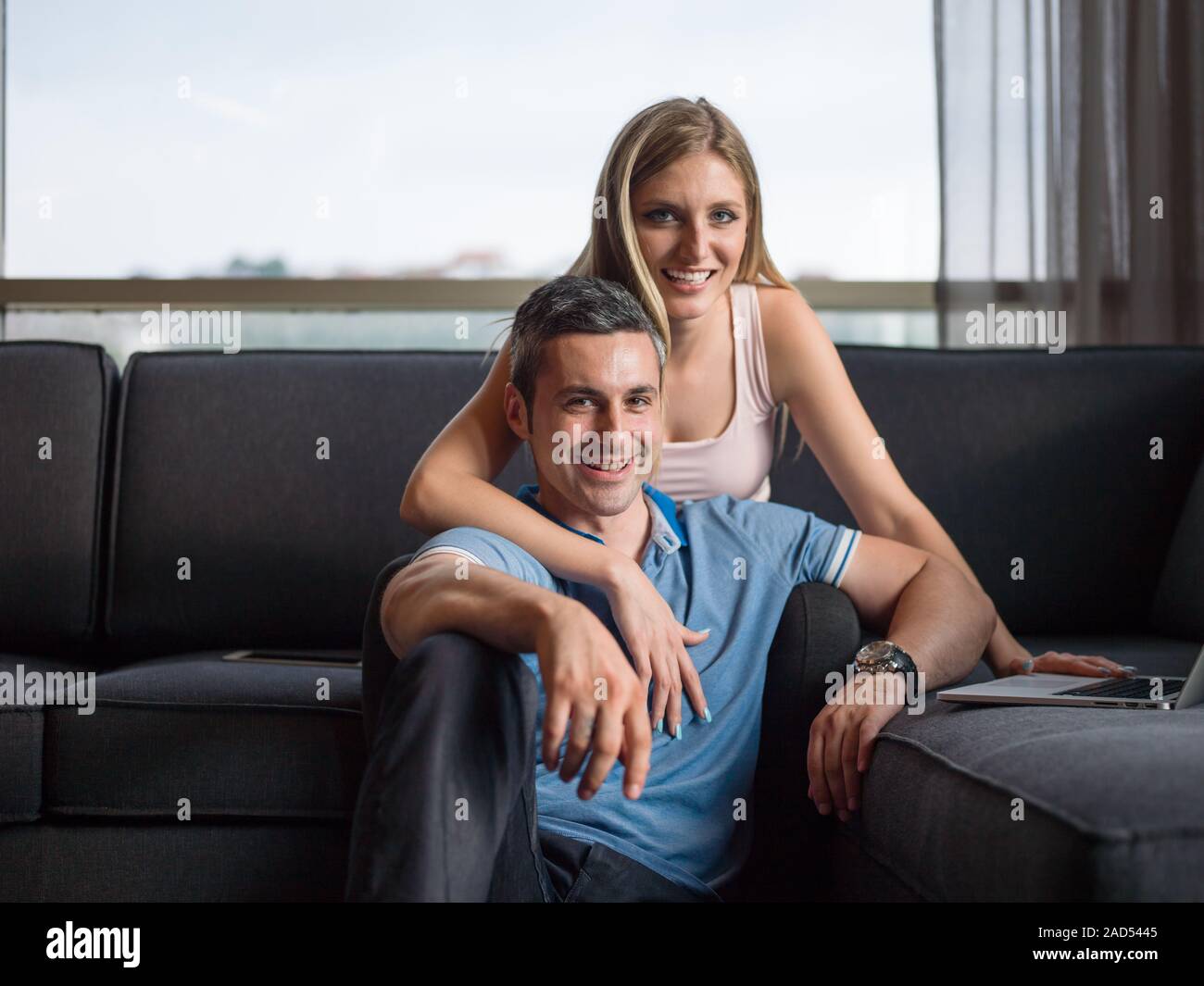 Attractive Couple Using A Laptop on couch Stock Photo - Alamy