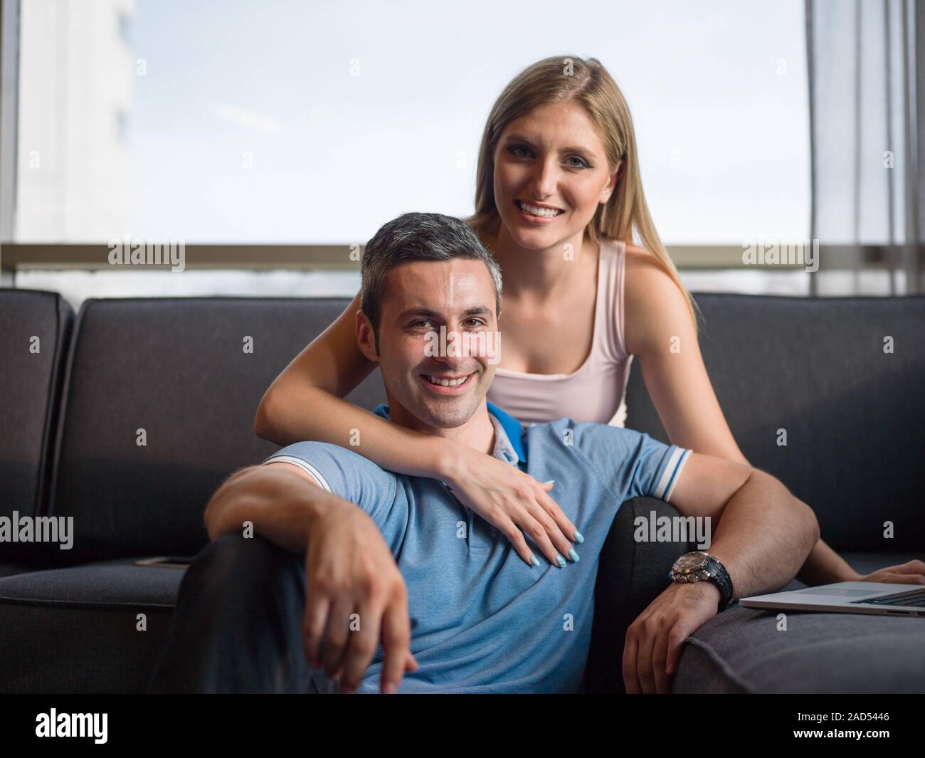 Attractive Couple Using A Laptop on couch Stock Photo - Alamy