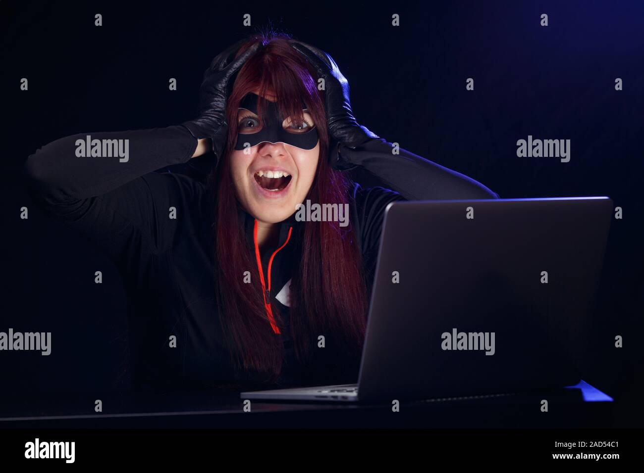 Brunette steals information from computer Stock Photo