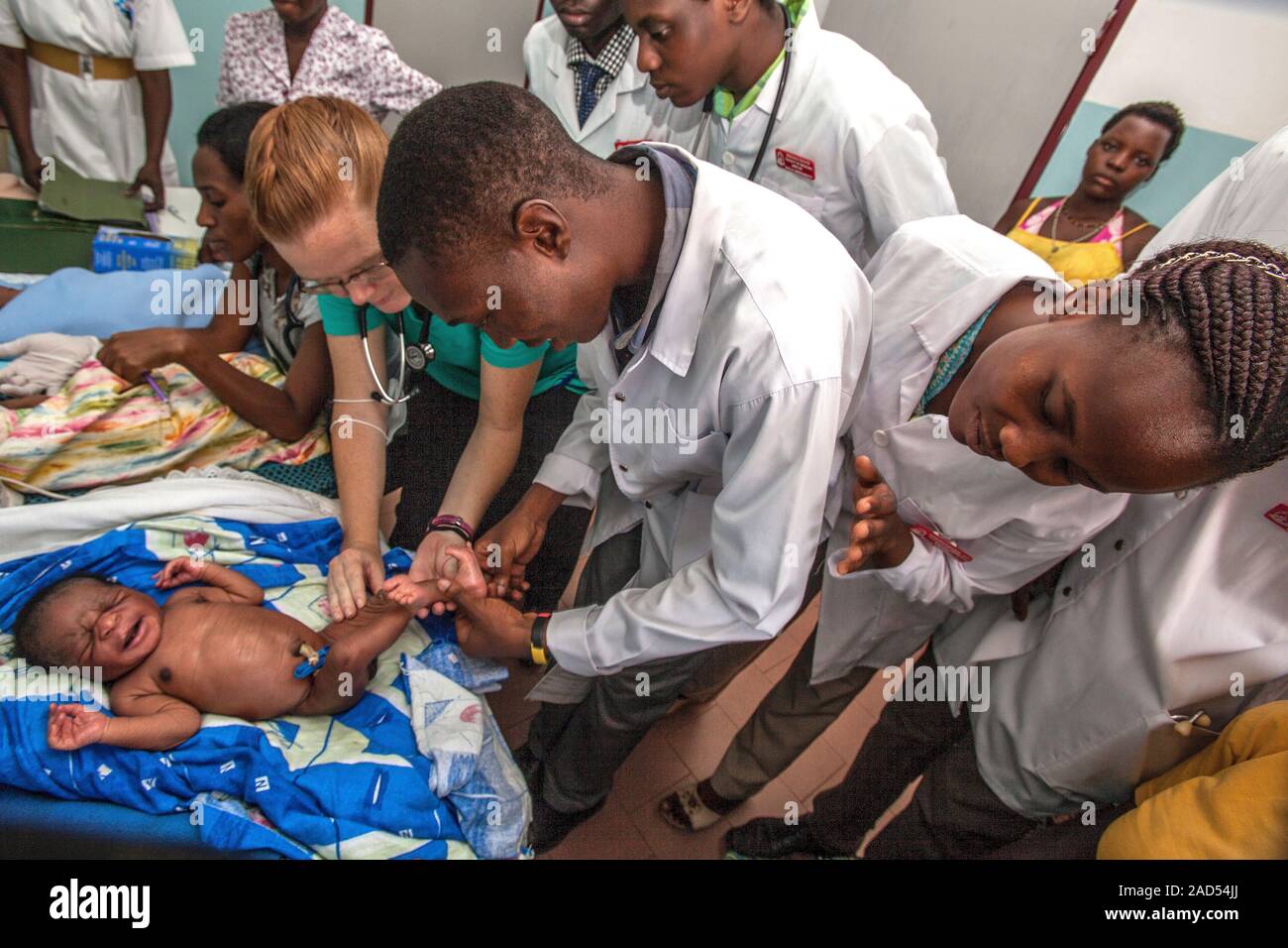 Hospital doctors examining newborn babies and testing their reflexes ...