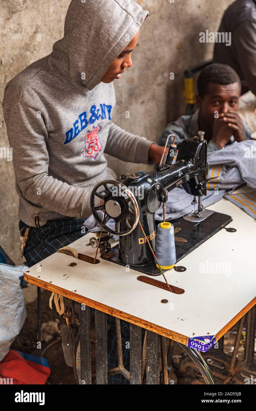 Ethiopia. Amhara. Debark. September 21, 2019. Man mending clothes with