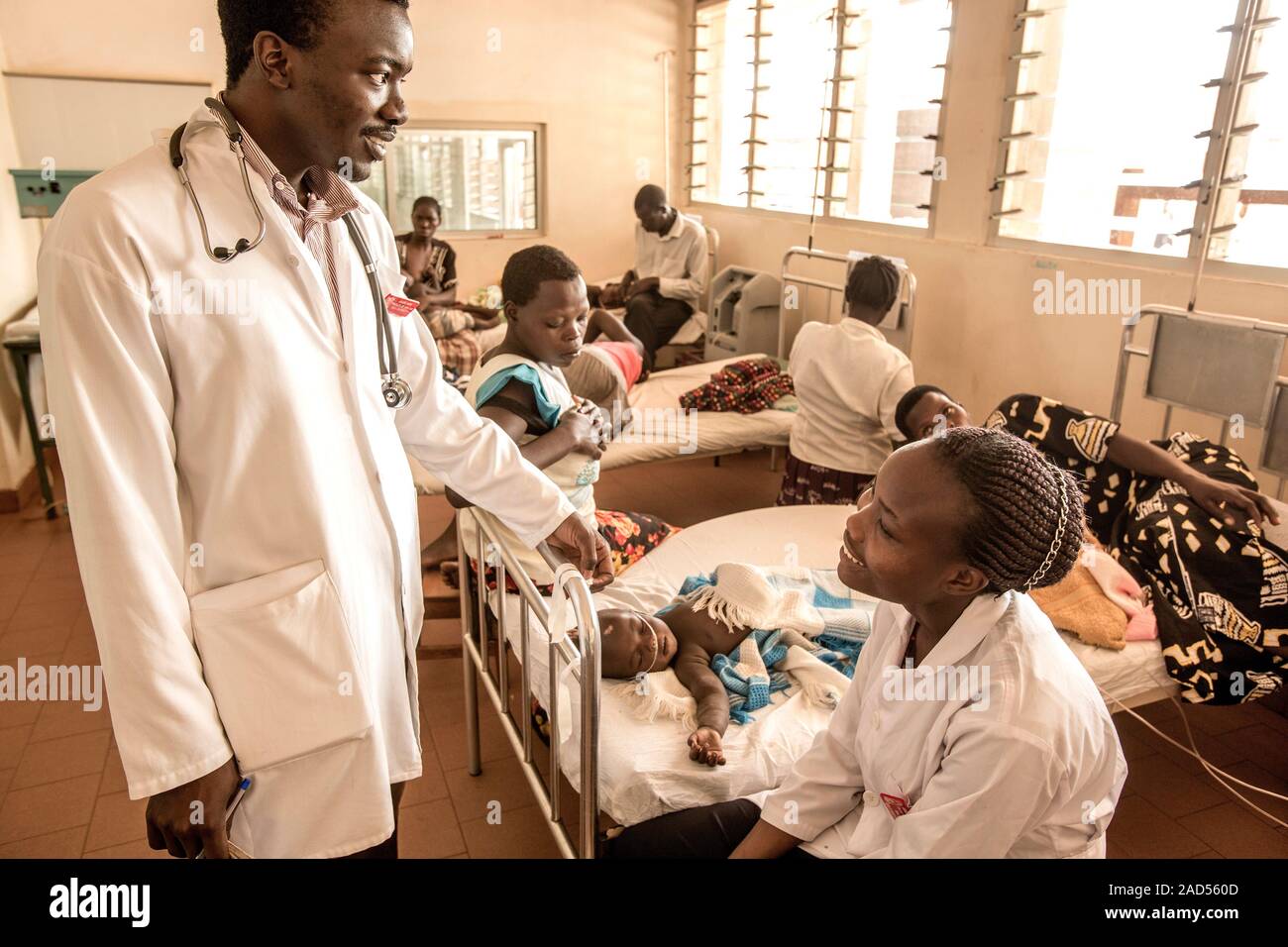 Hospital doctors, with mothers and sick children on the ward beds