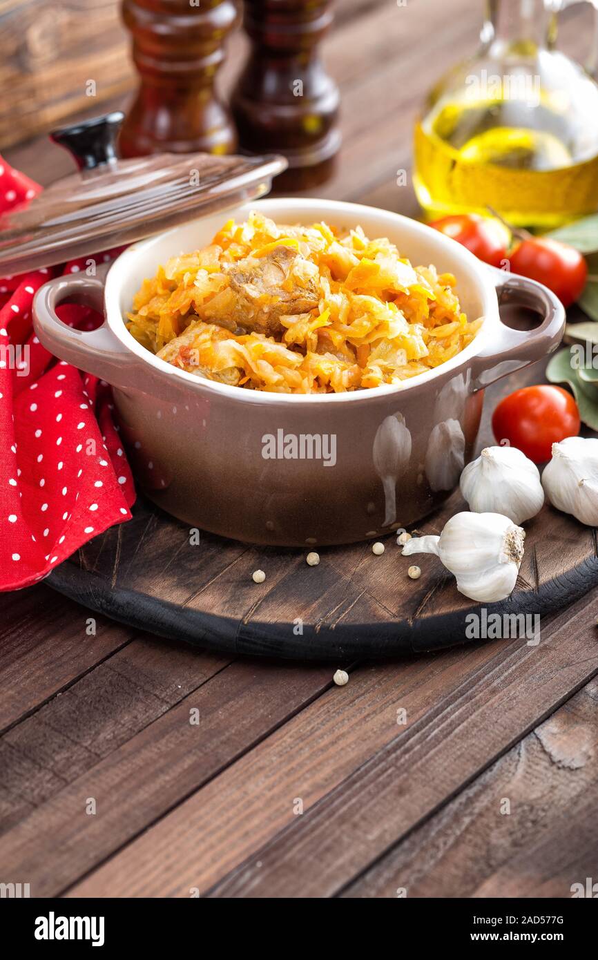 Stewed cabbage with meat on dark rustic wooden background Stock Photo