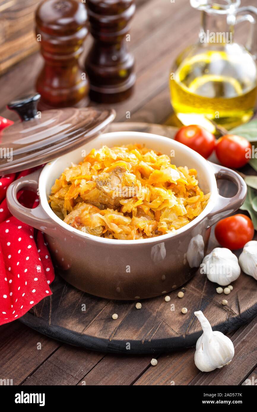 Stewed cabbage with meat on dark rustic wooden background Stock Photo