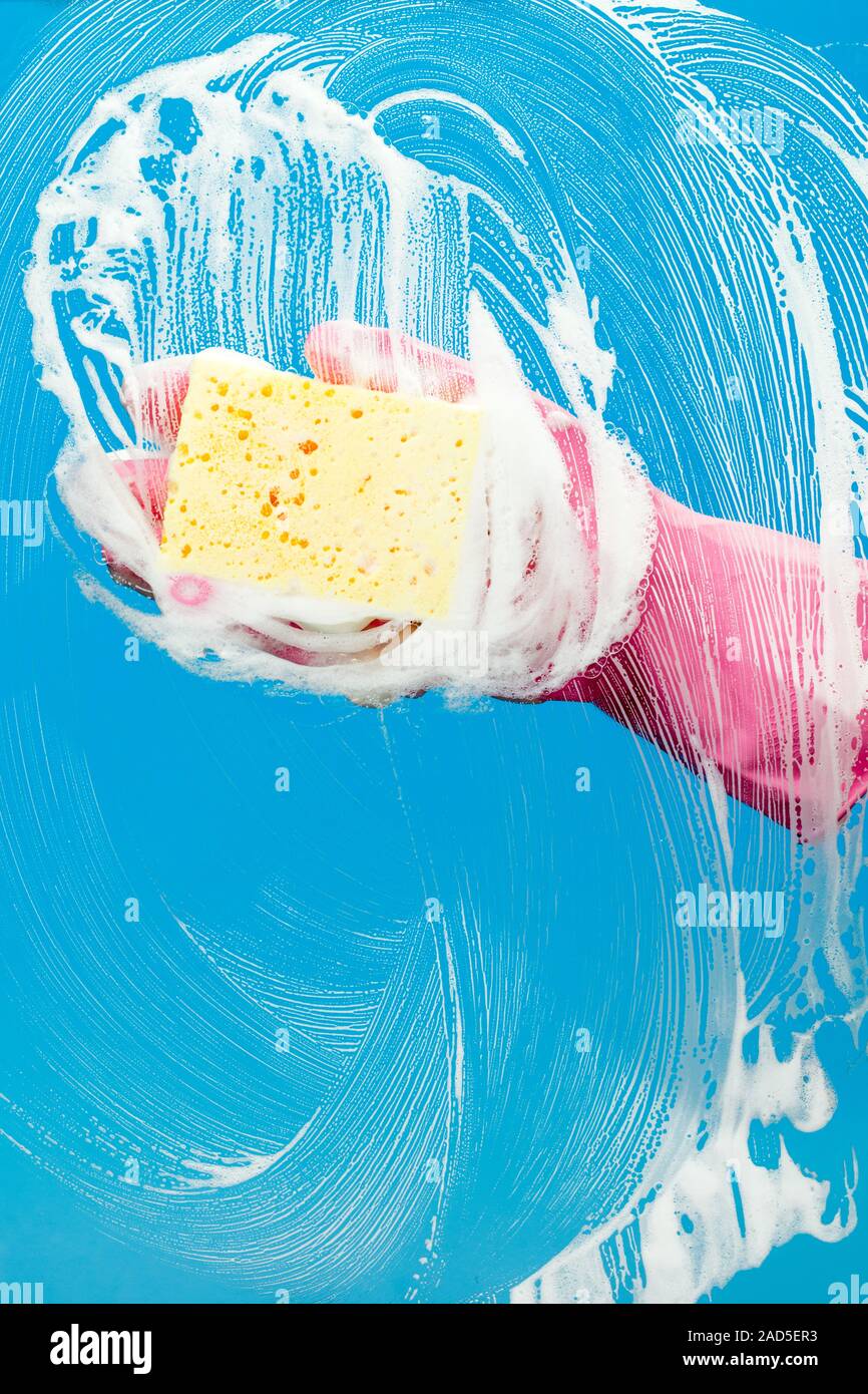 Man with glove cleaning window Stock Photo