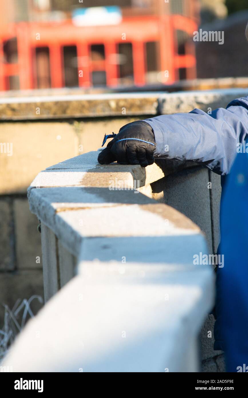 gloved hand being dragged along frost wood rail Stock Photo