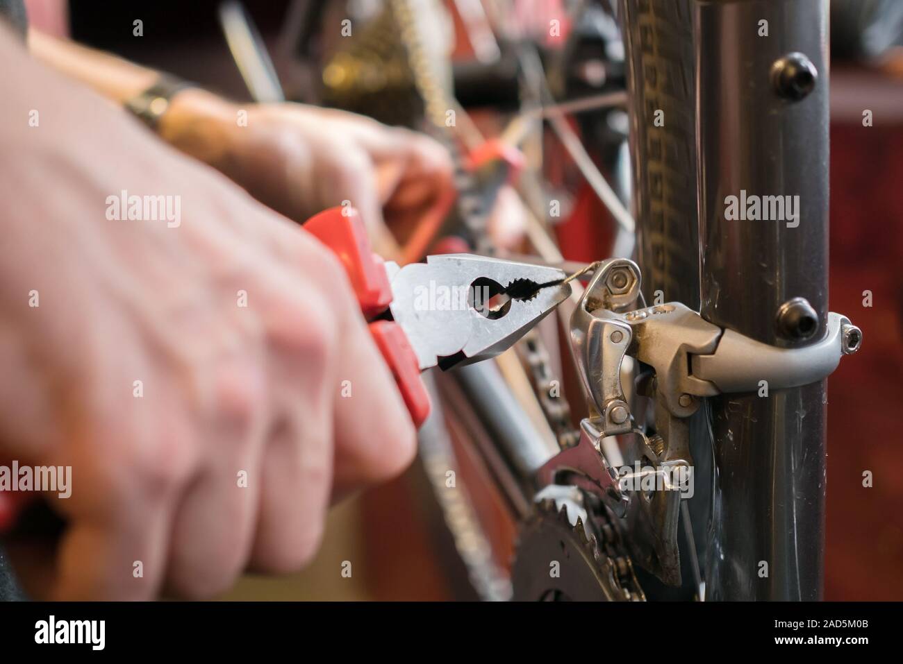 Man with pliers repairing bicycle Stock Photo