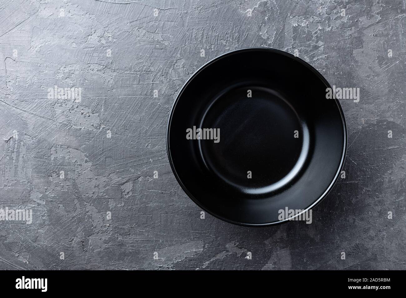 Empty black soup plate on dark grey background, top view Stock Photo