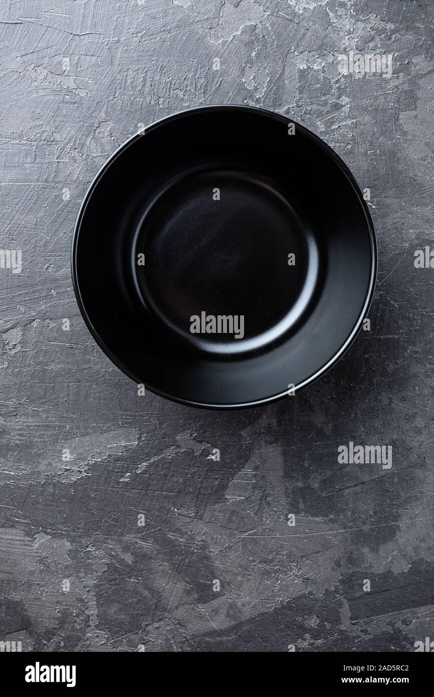 Empty black soup plate on dark grey background, top view Stock Photo