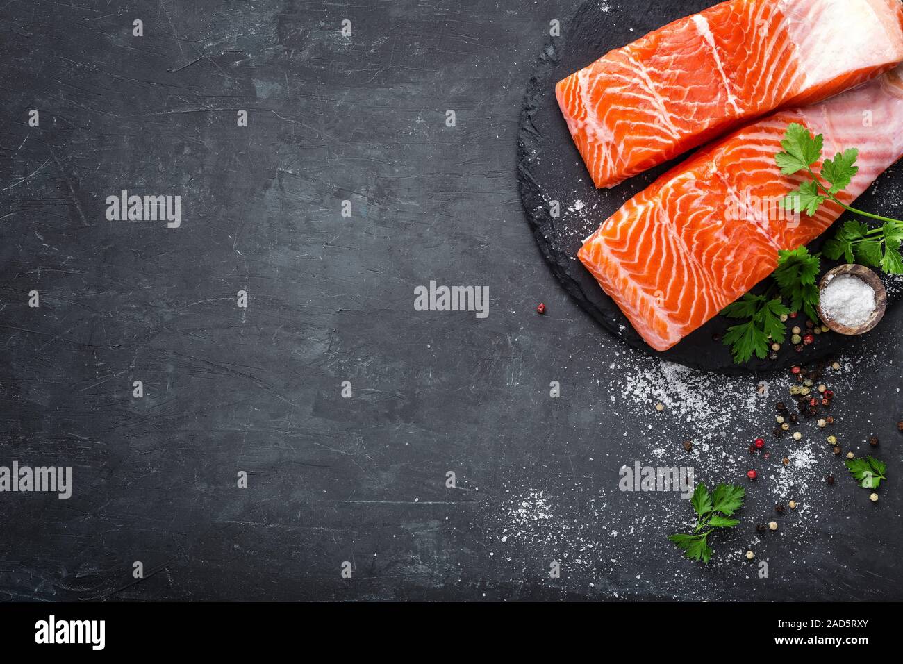 Raw salmon fish fillet on black background Stock Photo - Alamy