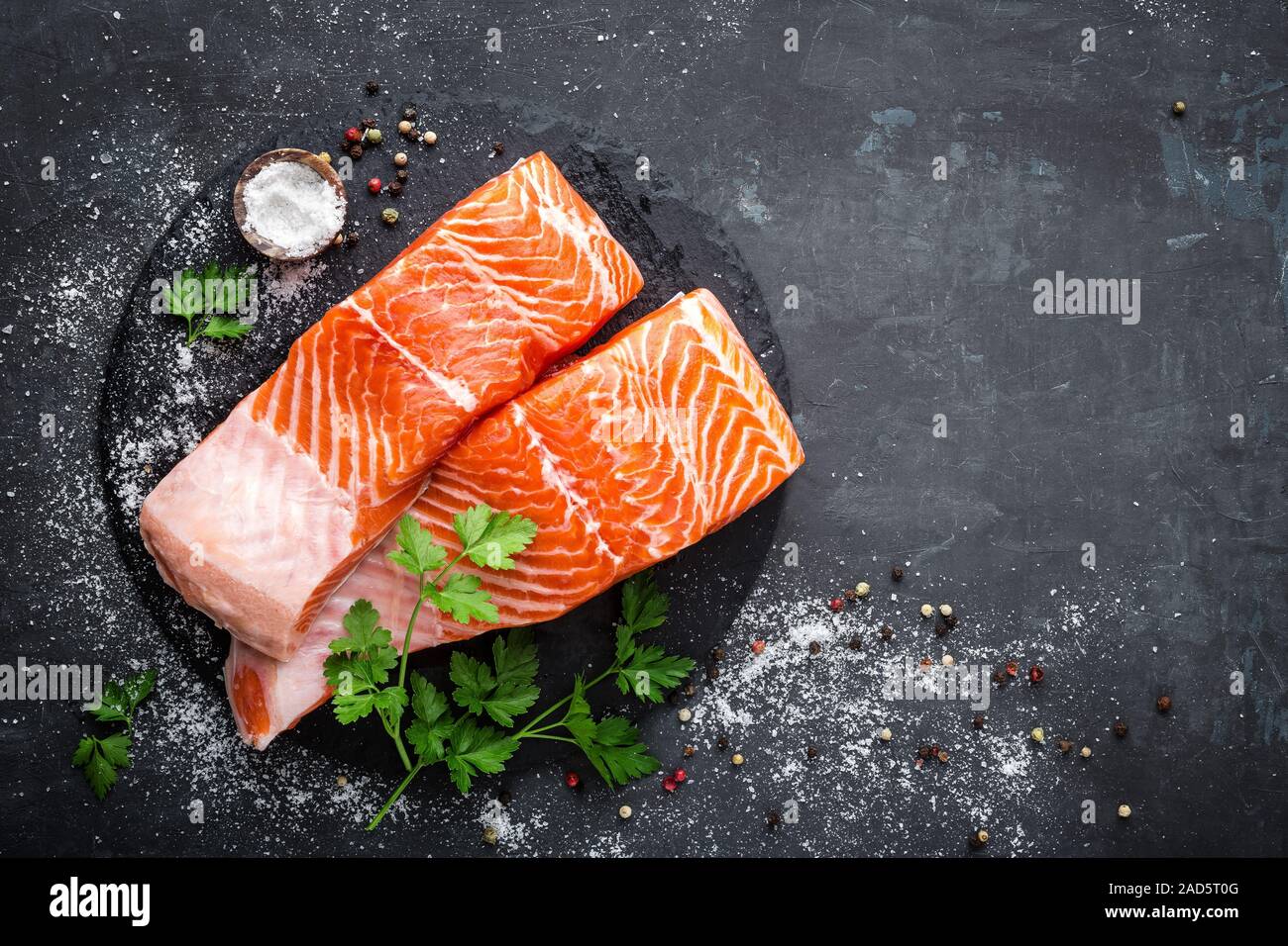 Raw salmon fish fillet on black background Stock Photo - Alamy