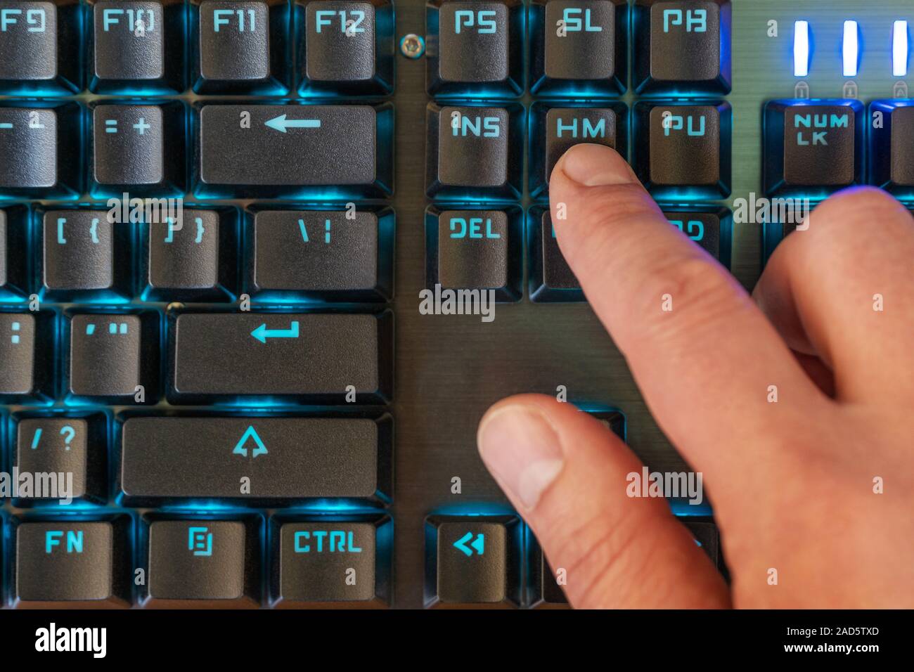 Male Finger Presses The Home Key On A Black Keyboard With Blue Backlight Stock Photo Alamy